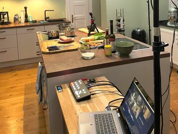 Kücheninsel mit Zutaten, Geräten und Laptop für Videoanruf.