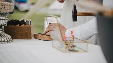 A craftsman hits a stamp with a hammer.