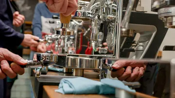 Espressomaschine, Menschen bedienen sie, in einem Kaffeeumfeld.