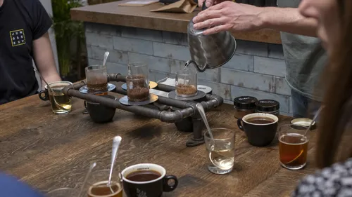 Eine Person gießt Wasser in ein Glas für Kaffee.