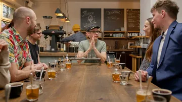 Gruppe diskutiert an einem Tisch in einem Café.