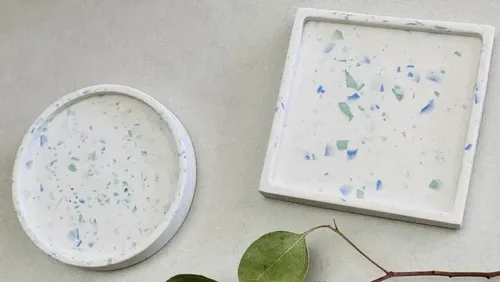Round and square coasters lie on a surface.
