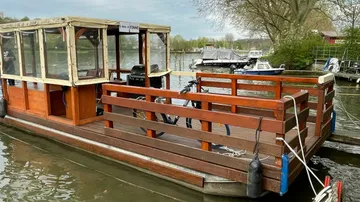 A wooden boat with a roof is lying on the shore.