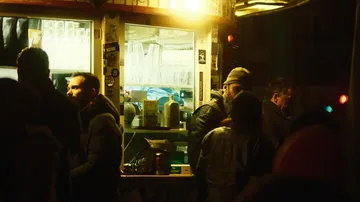Bar mit Menschen, die Getränke kaufen und plaudern.