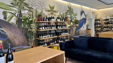Shelf with wine bottles surrounded by plant motifs in the room.