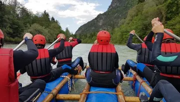 People row on an inflatable boat in nature.