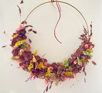 Kreisförmiger Blumenkranz hängt an der Wand.