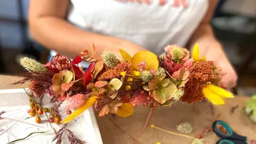 Colourful hair wreath is made surrounded by craft materials.