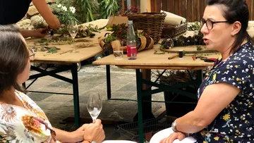 Zwei Frauen unterhalten sich in einem Garten über Dekoration.