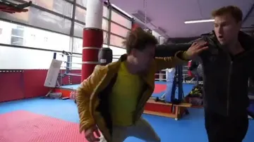 Two men sparring in a boxing gym.