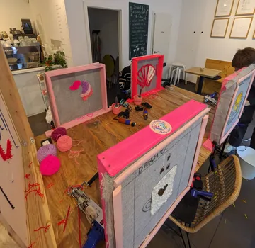 A table with an embroidery frame, crafts are made in a cafe.