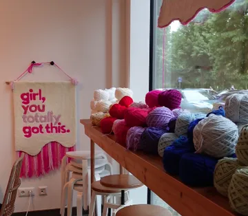 Colourful wool is lying on a table in a room.