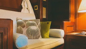 Ein Sofa mit bunten Kissen in einem warmen Raum.