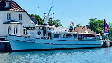 A boat is lying on the shore waiting for passengers.