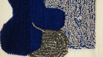 Texturierte Teppichkunst mit blauen und grauen Formen.