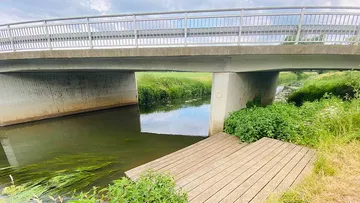 Bridge over a clear watercourse with an adjacent wooden walkway.
