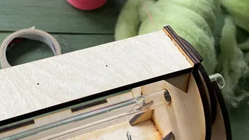 Holzrahmen liegt auf einem Tisch, Montagewerkzeuge bereit.