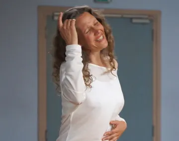 A smiling woman moves in a room.