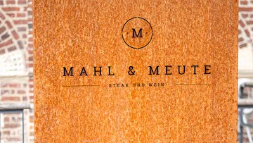 A sign shows 'MEAL & MEUTE' with 'STEAK AND WINE'.
