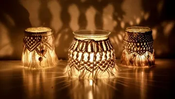 Three decorative candle holders light up and cast shadows.