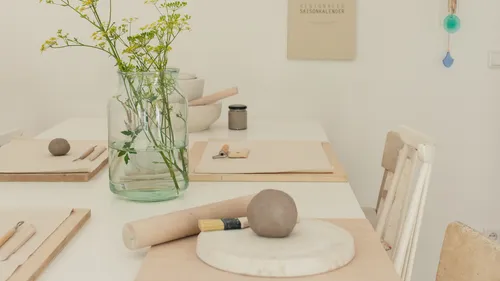 Tisch mit Arbeitsmaterialien für kreatives Arbeiten mit Ton.