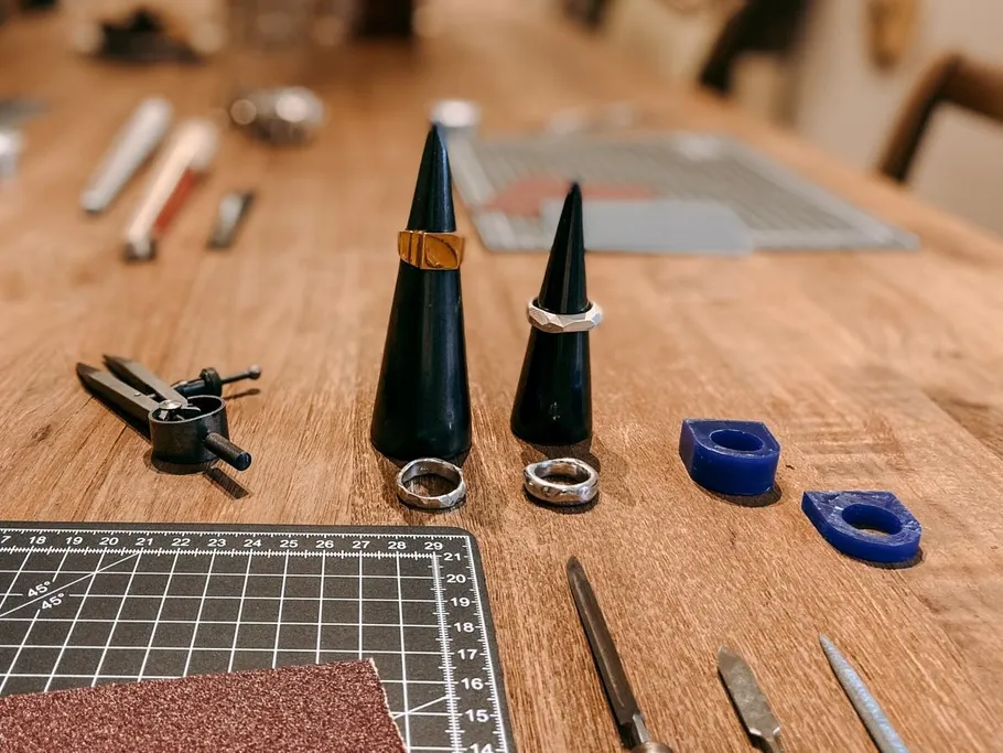 Rings stand on black stands, surrounded by tools.