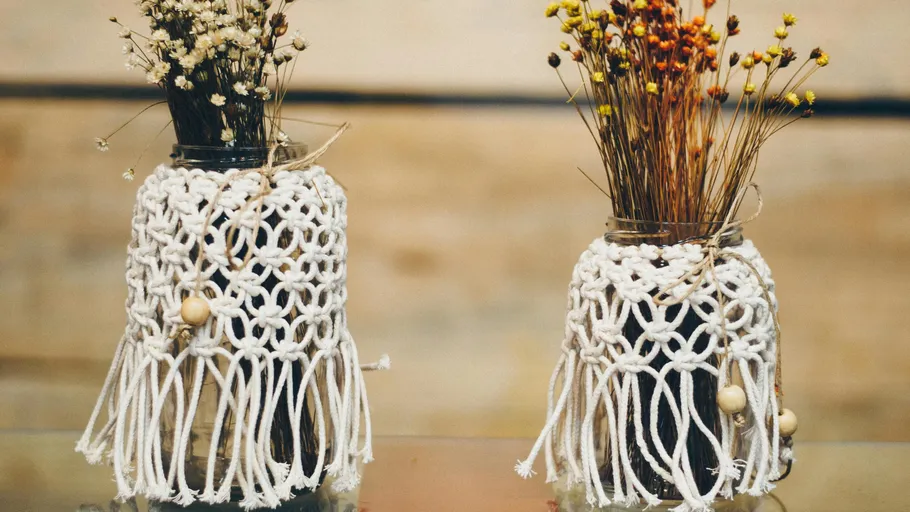 Two vases with dried flowers decorated with macrame