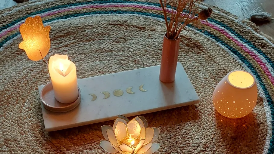 Candles and decorations are arranged on a round rug.