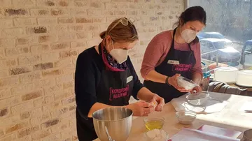 Zwei Frauen backen in einer lichtdurchfluteten Küche.