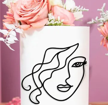 Vase with flowers with a stylized face drawing on it.