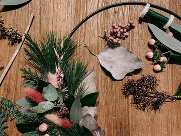 Colourful plant arrangements lie on a wooden background.