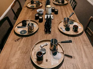 A table with several coffee cups and utensils.