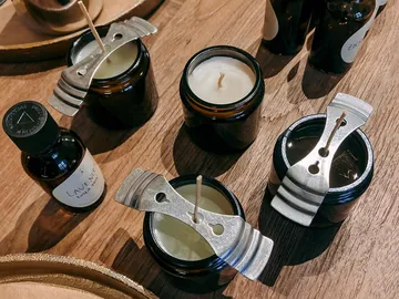 Candles with wicks and oil bottles on table.