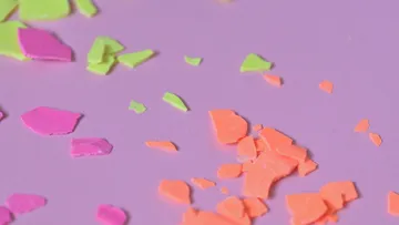 Colorful, broken pieces scattered on purple background.