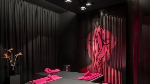 Modernes Spa-Zimmer mit schwarzem Dekor und rosafarbenen Akzenten.