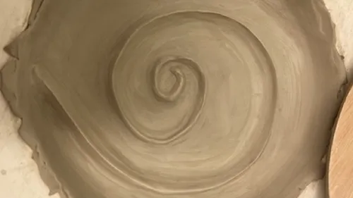 A clay spiral is formed in a creative studio.