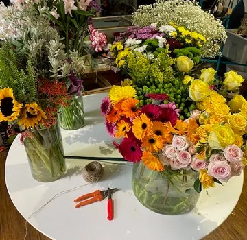 Bunte Blumen in Vasen auf einem Tisch arrangiert.