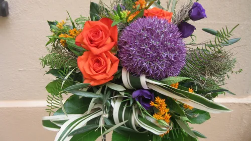 Colourful floral arrangements with red roses and purple orbs