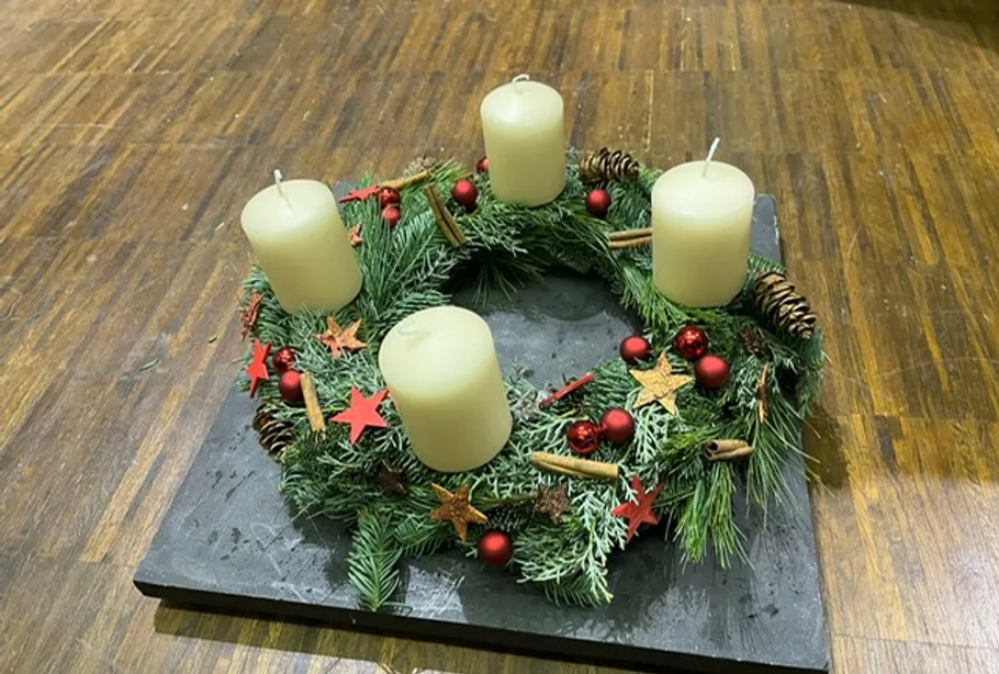 Ein Adventskranz mit vier Kerzen auf einem Tisch.