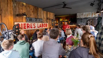 Beer seminar in a cozy environment, participants sit and listen.