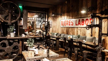 Wooden interior with tables and old machinery in a restaurant.