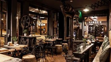 Industry-inspired restaurant with wooden chairs and tables.