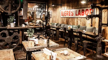 Wooden tables with chairs in a cozy brewery.