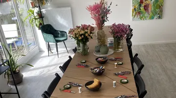 A set table with flowers, snacks, and craft materials.