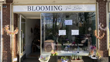 Flower boutique with offers and decorative elements in the shop window.