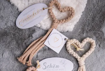 Heart-shaped keychains lie on soft grey fabric.