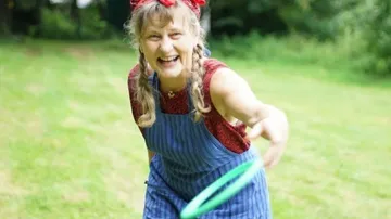 A woman throws a frisbee in a park.