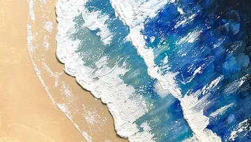 Farbige Wellen brechen auf einer sandfarbenen Fläche.
