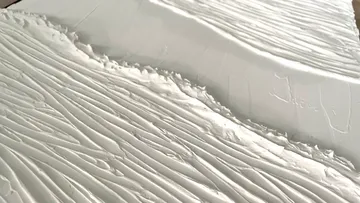 White surface with textured, wave-like grooves