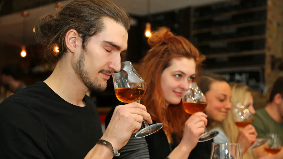 Männer und Frauen riechen und bewerten Getränke in Bar.